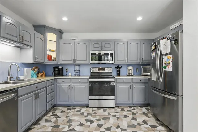 a kitchen with stainless steel appliances granite countertop a refrigerator sink and stove