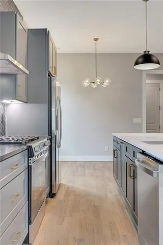 a kitchen with stainless steel appliances granite countertop a stove and a refrigerator