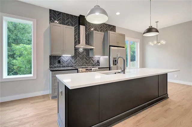 a kitchen with kitchen island granite countertop a sink a counter space appliances and a window