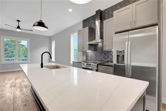 a kitchen with stainless steel appliances granite countertop a sink a stove and a refrigerator