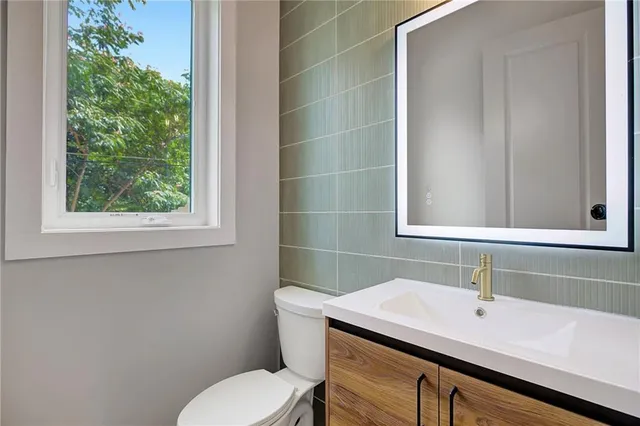 a bathroom with a sink a toilet and a mirror