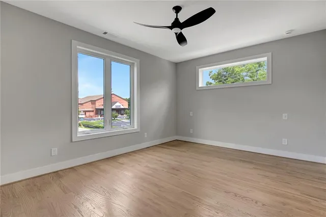 a view of a hallway with wooden floor and a bathroom