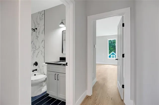 a bathroom with a sink a toilet and shower