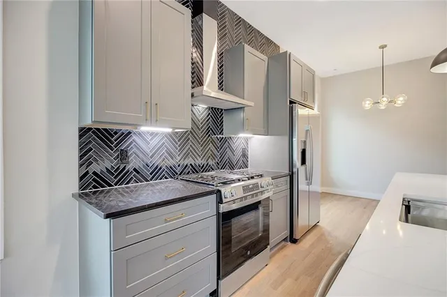 a kitchen with stainless steel appliances granite countertop a stove and a refrigerator