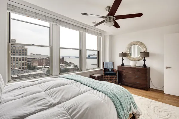 a bedroom with a bed and a large window