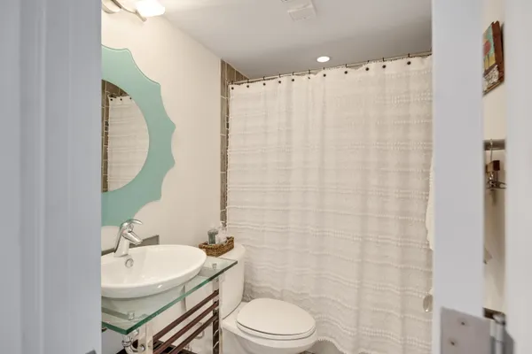 a bathroom with a sink a toilet and shower curtain