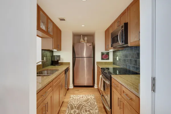 a kitchen with stainless steel appliances granite countertop a refrigerator and a sink