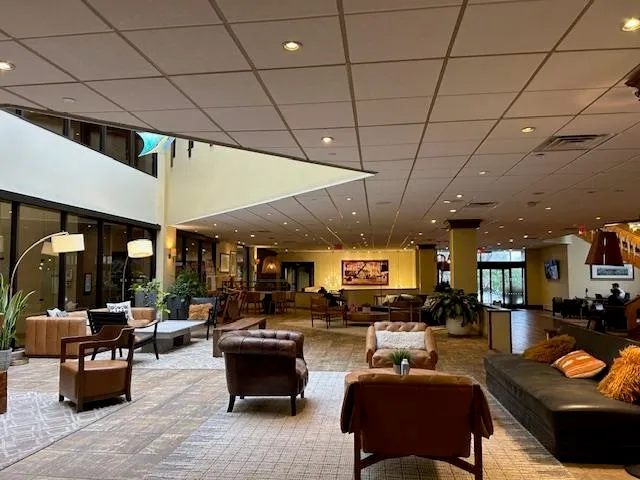a living room with furniture kitchen view and a large window