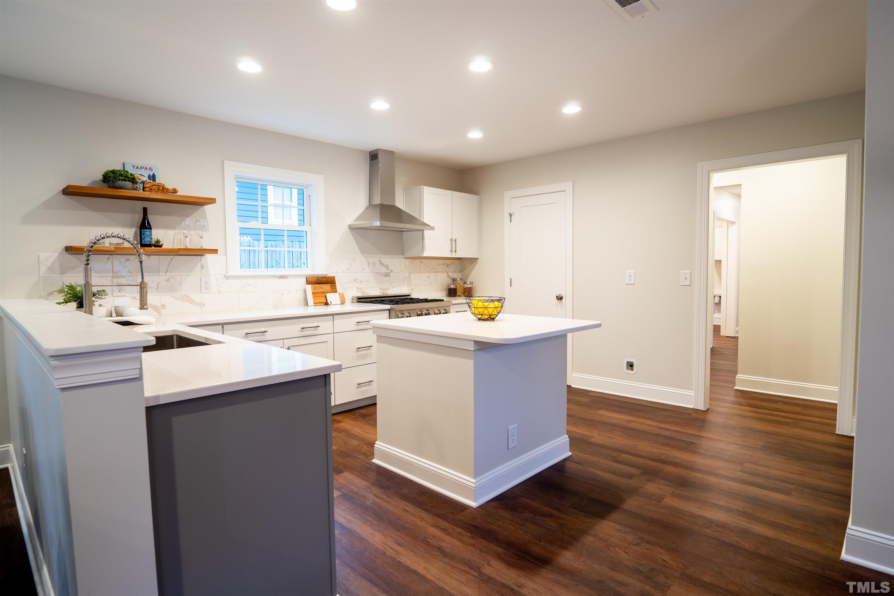 910 South East Street Raleigh, NC 27601 - Photo 12 of 17 a kitchen with kitchen island a sink a stove and a window