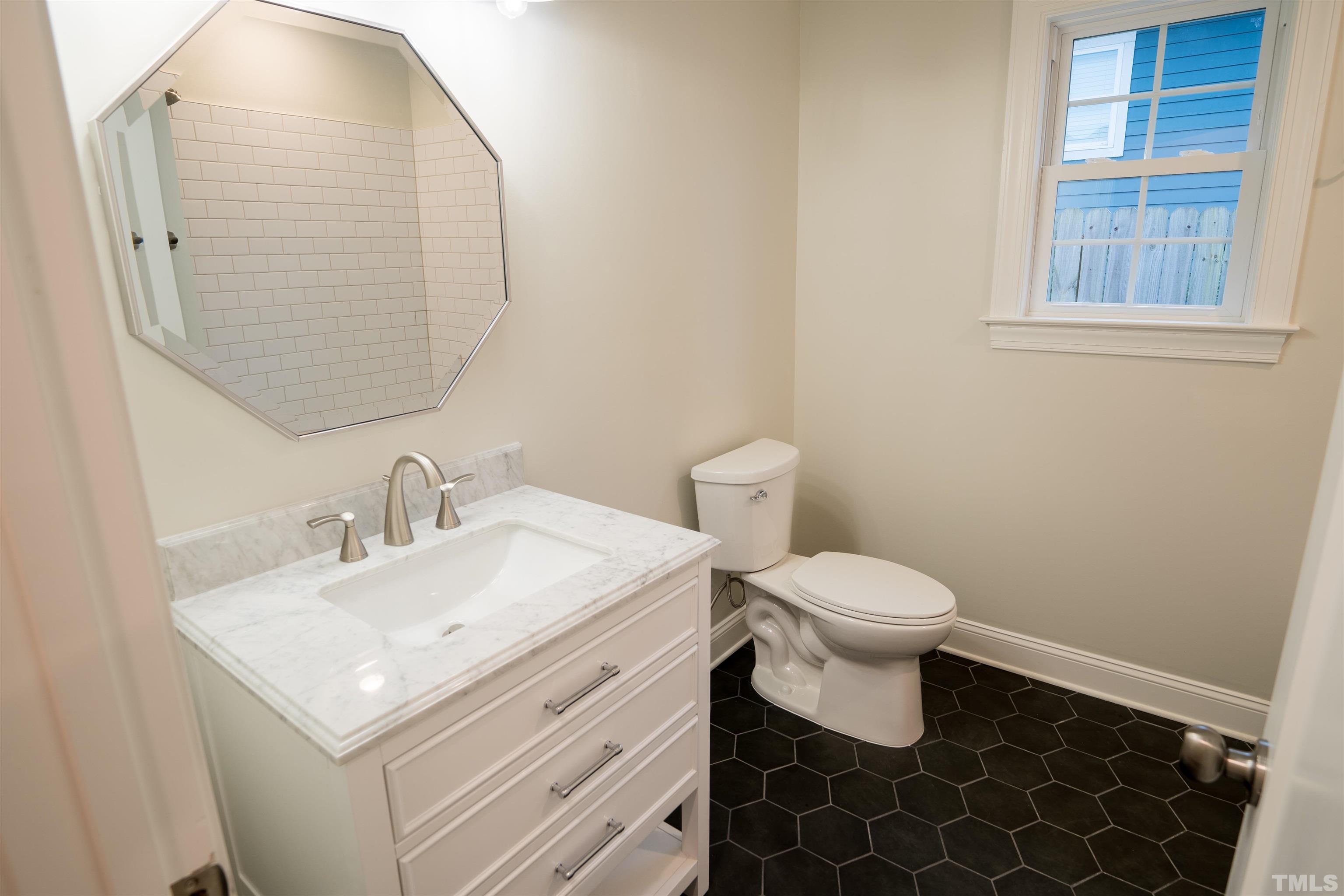 910 South East Street Raleigh, NC 27601 - Photo 9 of 17 a bathroom with a sink toilet and mirror