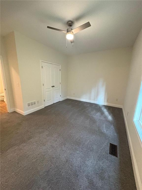 1487 Mt Zion Road Oxford, GA 30054 - Photo 13 of 18 an empty room with a ceiling fan and carpet