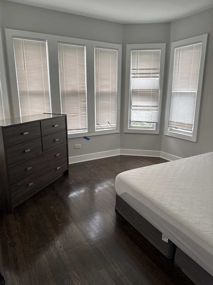 310 West 105th Street Chicago, IL 60628 - Photo 5 of 22 a bed sitting in a spacious bedroom next to a window