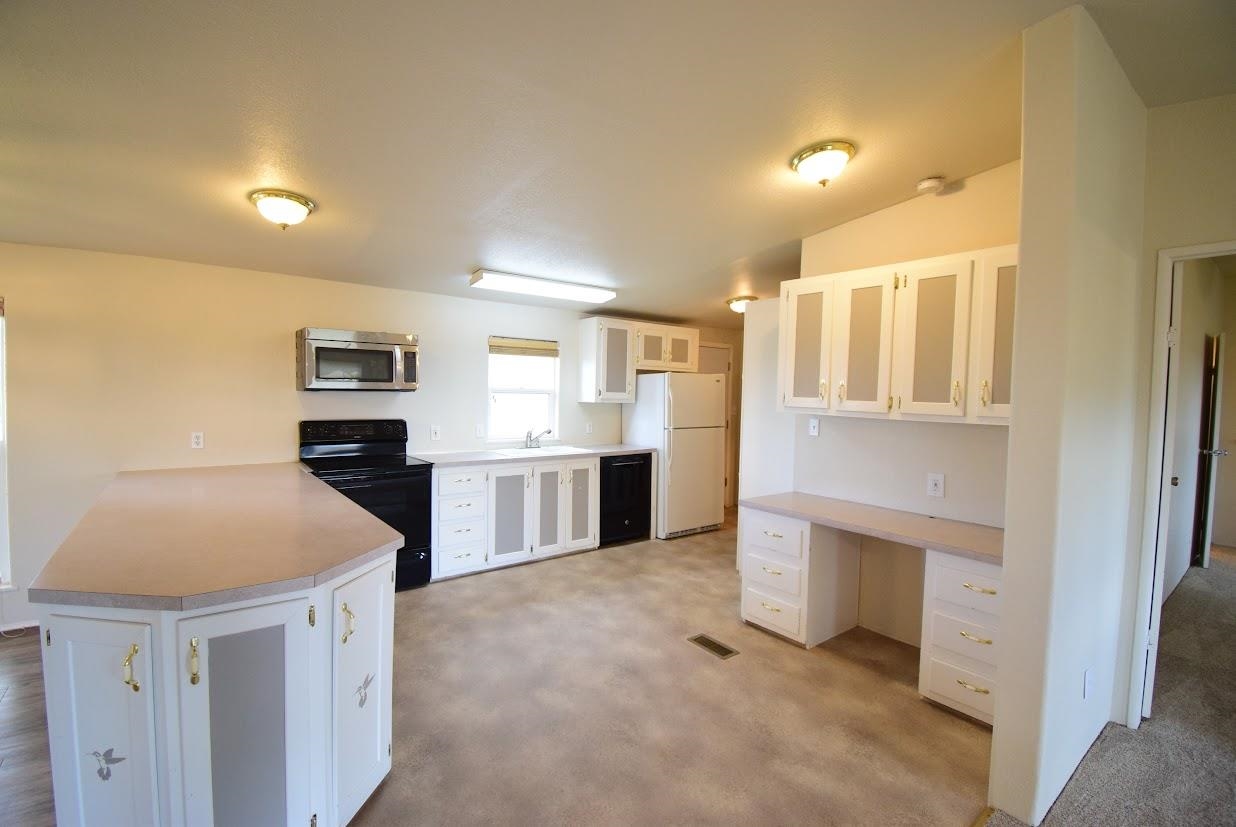 19548 B50 Road Delta, CO 81416 - Photo 7 of 37 a kitchen with stainless steel appliances kitchen island a refrigerator sink and cabinets