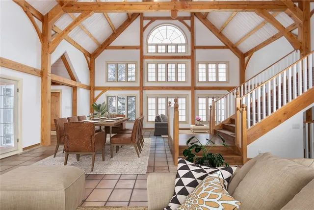 a living room with lots of white furniture and floor to ceiling windows