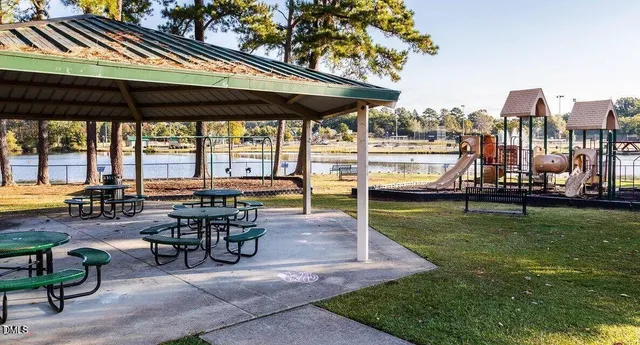 a view of a swimming pool with a bench and trees around