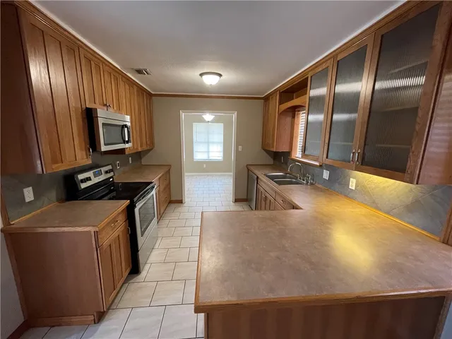 a kitchen with stainless steel appliances a stove a sink a microwave oven and a refrigerator