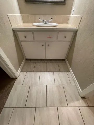 a bathroom with a sink a glass door shower and vanity