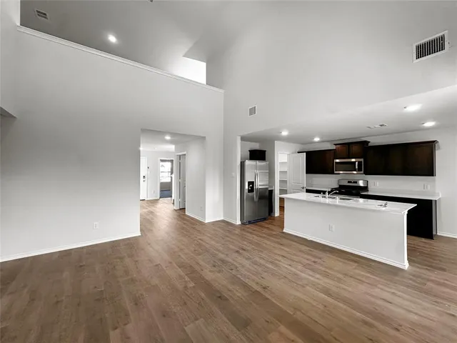 a view of kitchen with microwave a stove and wooden floor