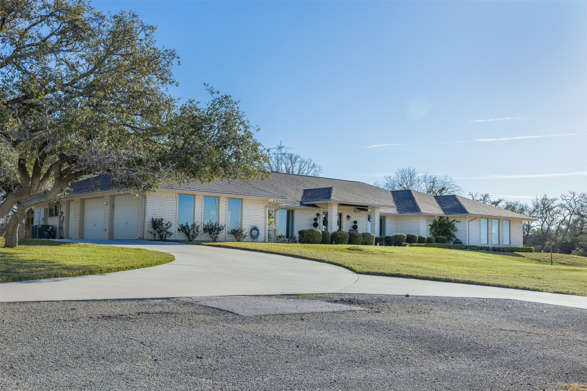 a front view of a house with a yard and trees
