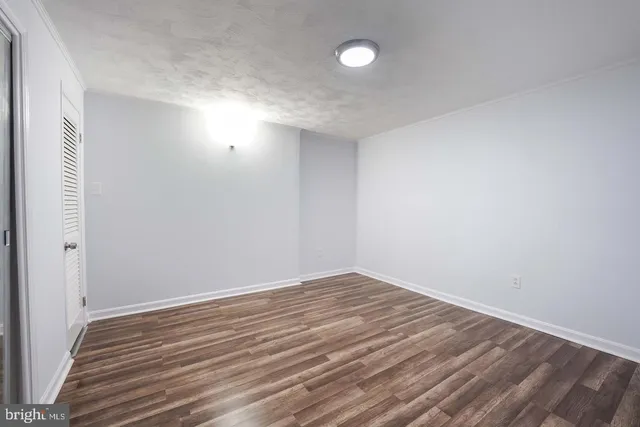 a view of room with wooden floor and white walls