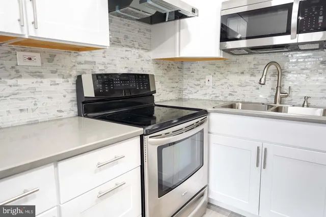 a kitchen with stainless steel appliances a stove a sink and a microwave