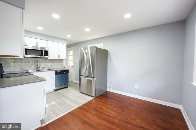 a kitchen with stainless steel appliances a refrigerator and a stove top oven