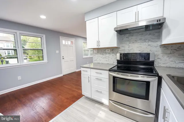 a kitchen with granite countertop wooden cabinets stainless steel appliances and a window