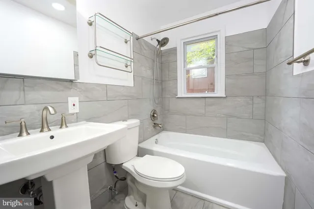 a bathroom with a sink mirror toilet and bathtub