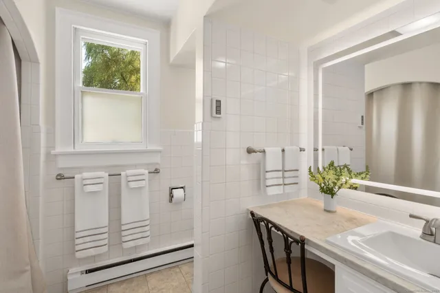 a bathroom with a granite countertop sink a mirror and a shower