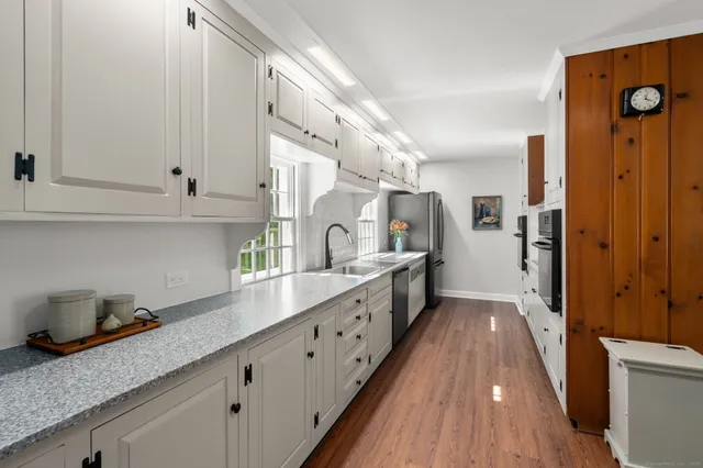 a kitchen with granite countertop a sink a stove and cabinets