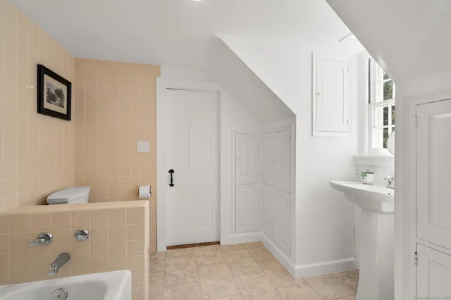 a bathroom with a bathtub sink and mirror