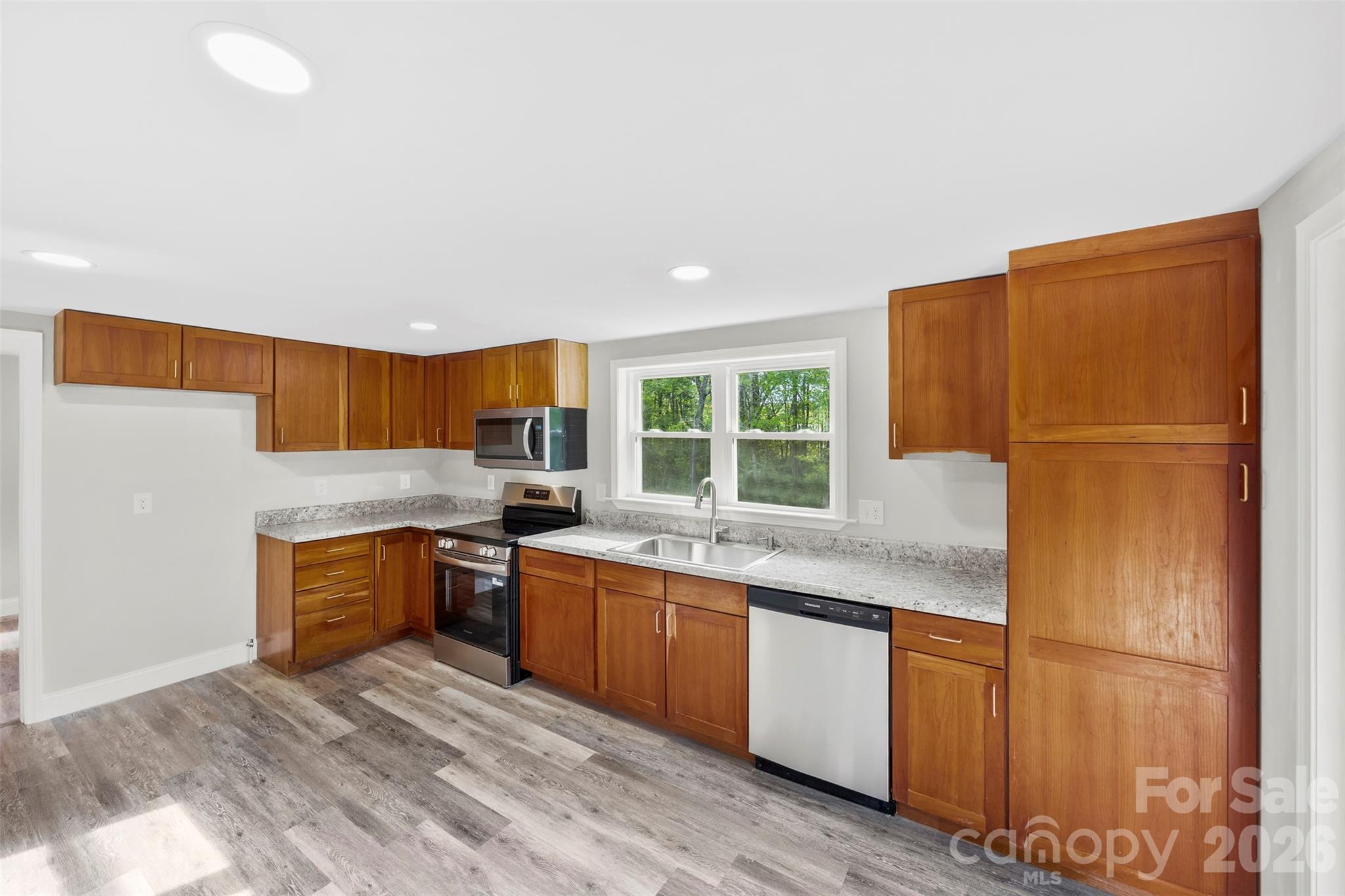 858 High Shoals Church Road Mooresboro, NC 28114 - Photo 5 of 25 a kitchen with stainless steel appliances granite countertop a refrigerator a sink dishwasher a stove with wooden cabinets and floors