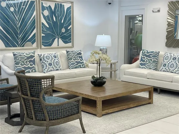 a living room with furniture a rug and wall paintings