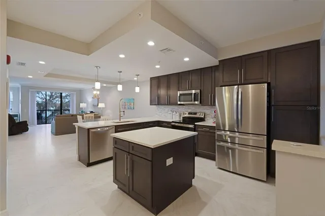 a kitchen with kitchen island a sink stainless steel appliances and cabinets