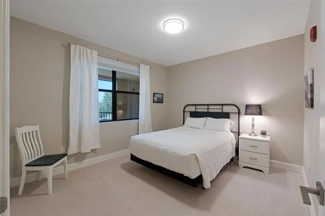 a bedroom with a bed chair and window