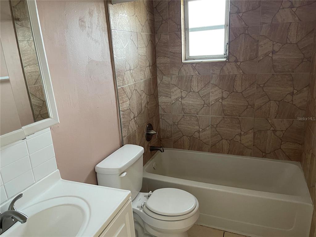 5924 Pine Street New Port Richey, FL 34652 - Photo 12 of 20 a white toilet and tub sitting next to a bathroom sink