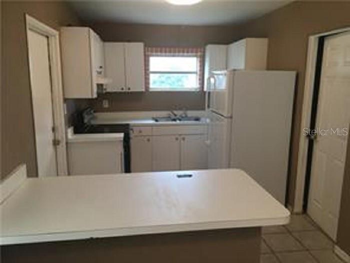 5924 Pine Street New Port Richey, FL 34652 - Photo 15 of 20 a room with a refrigerator and a stove