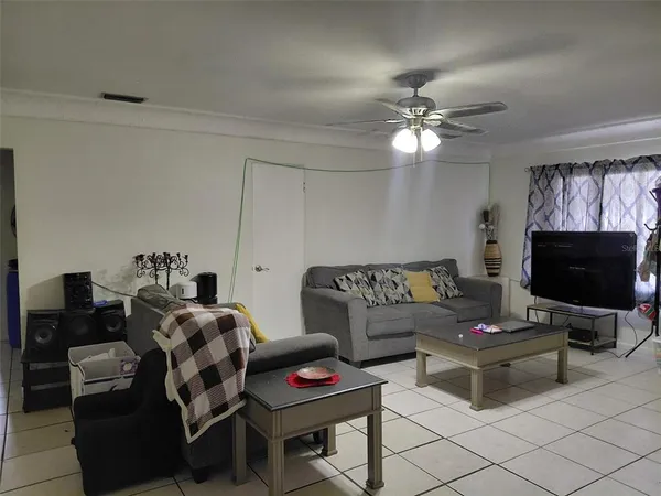 a living room with furniture a flat screen tv and a window