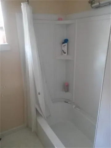 an empty room with wooden floor cabinet and windows