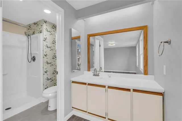 a bathroom with a sink a toilet and shower