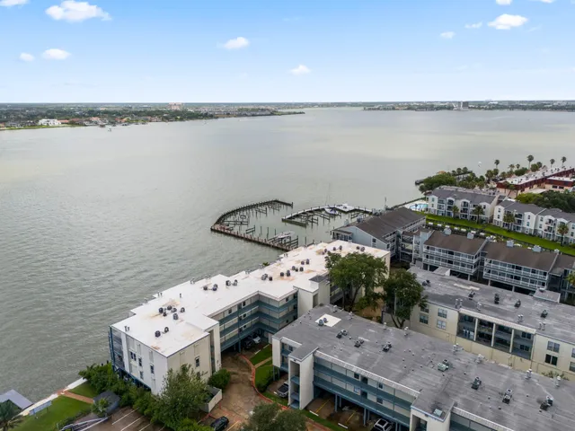an aerial view of residential houses with outdoor space and lake view