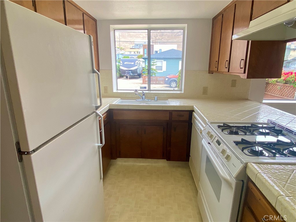 3219 Tide Avenue Morro Bay, CA 93442 - Photo 16 of 23 a kitchen with a stove a refrigerator and a sink