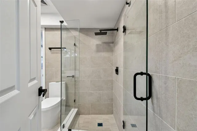 a bathroom with a shower a toilet and sink