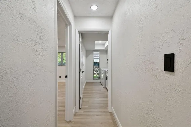 a view of a hallway with wooden floor