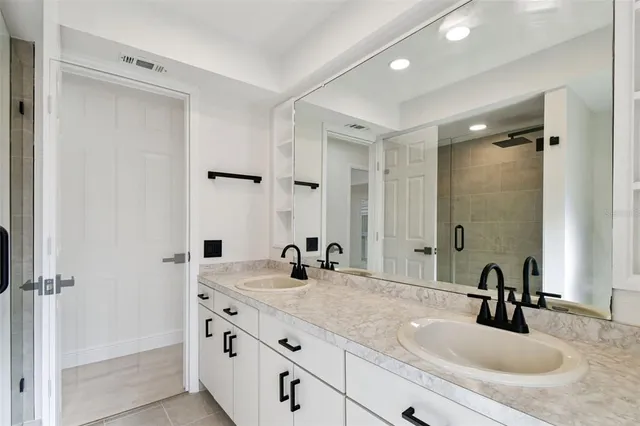a bathroom with double vanity sinks and a mirror