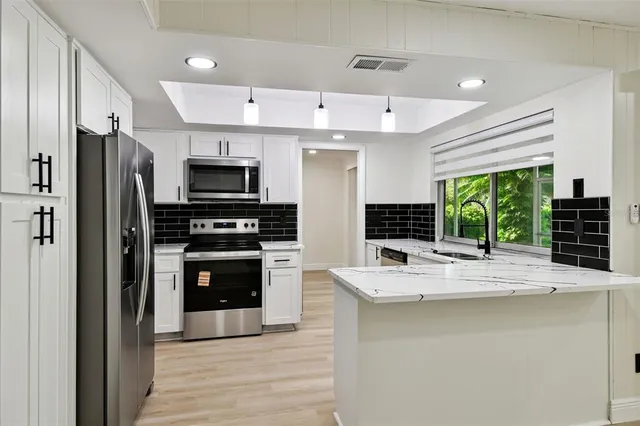 a kitchen with stainless steel appliances a stove sink and a refrigerator