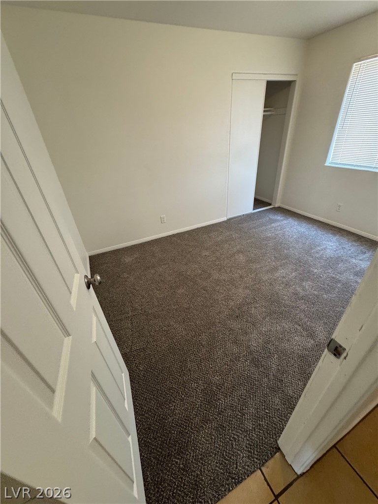 1448 Star Road, Unit 1 Pahrump, NV 89048 - Photo 11 of 12 A well-lit bedroom features plush carpeting and a convenient sliding closet.
