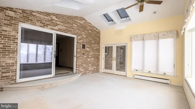 a view of an empty room with a fireplace and a window