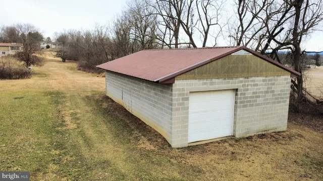 a backyard of a house with large trees and garage