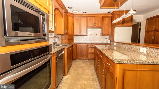 a kitchen with stainless steel appliances granite countertop a sink and a microwave